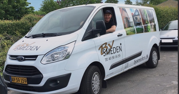 Firmabil med Bysmeden logo parkeret ved kunde